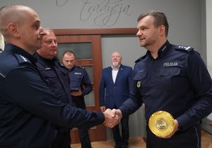 Inspektor Norbert Kurenda gratuluje podając rękę i przekazuje puchar policjantowi