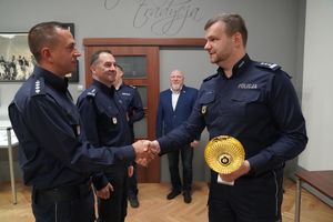 I Zastępca Komendanta Wojewódzkiego Policji inspektor Norbert Kurenda gratuluje i przekazuje puchar policjantowi