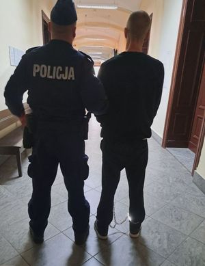 policjant prowadzi zatrzymanego