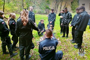 Uczniowie klasy mundurowej z policjantem pieką kiełbaski na ognisku