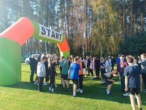 młodzież na sportowo ubrana przy banerze start