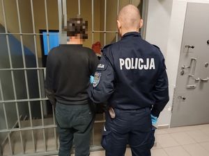 Policjant prowadzący zatryzmanego do celi