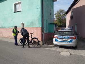 Policjantka sprawdza rower i rowerzystę.