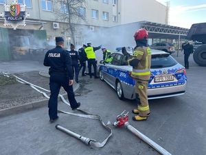 straż pożarna i policja przy radiowozie podczas ćwiczeń