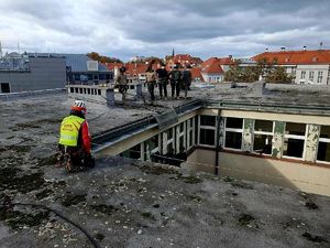 pracownik Górskiego Ochotnicze Pogotowie Ratunkowego wraz z policjantami na dachu budynku