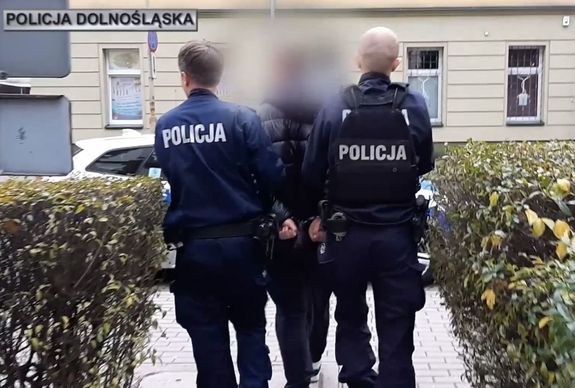 policjanci prowadzą zatrzymanego mężczyznę