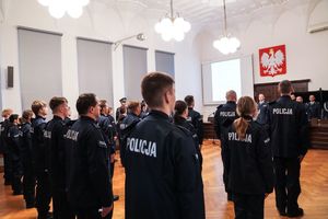 nowo przyjęci policjanci w szeregu - zdjęcie od tyłu