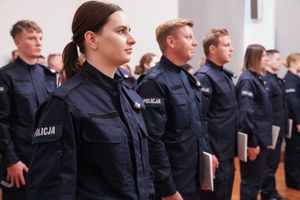 nowo przyjęci policjanci i policjantki po ślubowaniu stoją w dwuszeregu