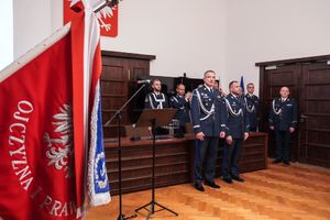 Komendant Wojewódzki Policji we Wrocławiu nadinspektor Paweł Półtorzycki i jego zastępca patrzą na sztandar