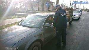 policjant kontroluję kierowce w samochodzie osobowym