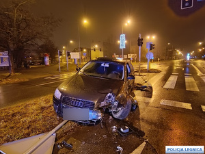 samochód osobowy po zderzeniu ze znakiem drogowym z oderwanym przednik kołem - widok z przodu