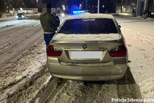 srebrny samochód osobowy na ośnieżonej  ulicy