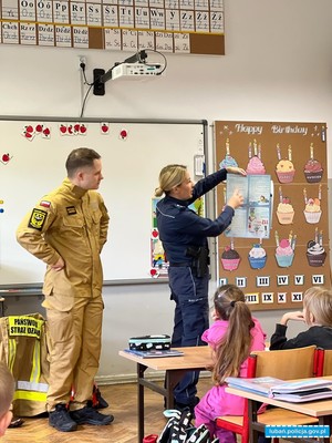 policjantka pokazuje ulotkę dzieciom