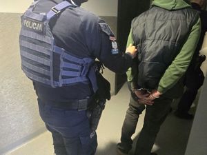 zatrzymany w kajdankach prowadzony przez policjanta