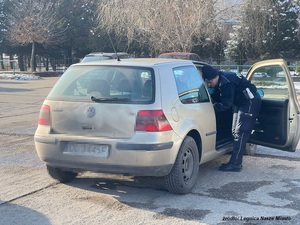 policjant zagląda do samochodu osobowego od trony pasażera