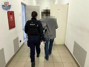 Policjantka prowadzi zatrzymanego