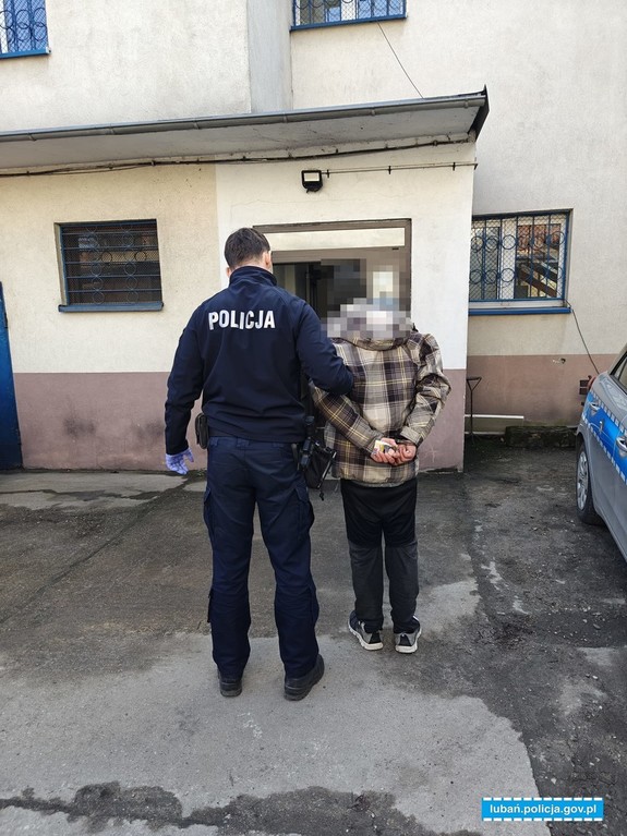 policjant prowadzi zatrzymanego
