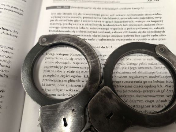 kajdanki leżące na kodeksie karnym