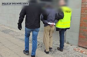 policjanci prowadzą zatrzymanego