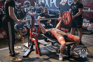 mężczyzna podczas zawodów podnosi sztangę