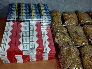 tytoń w woreczkach leżący na stole i paczki papierosów