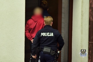 policjantka prowadzi zatrzymanego