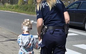 policjantka prowadzi dziecko za rękę
