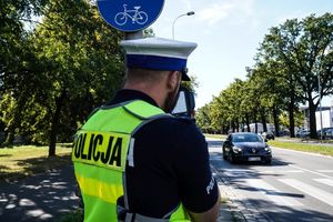 policjant mierzący radarem prędkość nadjeżdżającego pojazdu