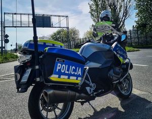 motory policyjny i przed nim policjant z radarem