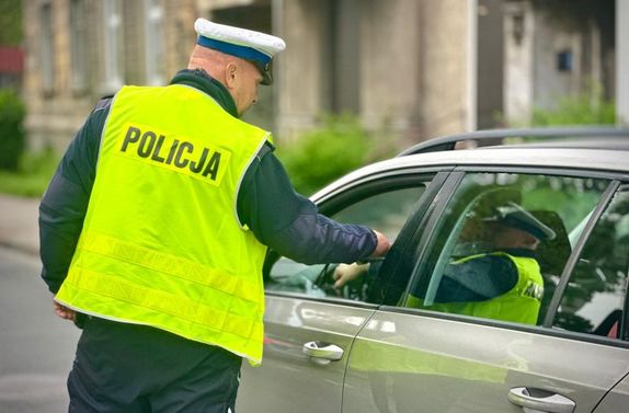 policjant sprawdza trzeźwość kierowcy samochodu osobowego