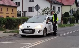policjant kontrolujący trzeźwość kierowcy samochodu osobowego