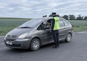 policjant kontrolujący trzeźwość kierowcy samochodu osobowego