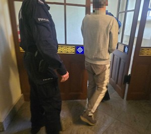 policjant prowadzi zatrzymanego