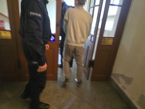 policjant prowadzi zatrzymanego