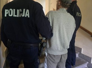 policjant prowadzi zatrzymanego
