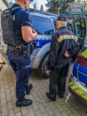 policjant ze starszym panem koło radiowozu