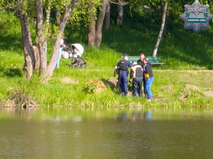 policjanci i przechodzień wyciągają seniora, który wpadł do wody