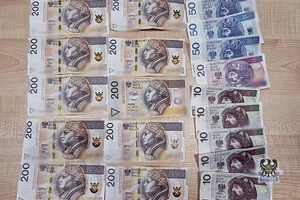 rozłożone na stole banknoty w polskim nominale po 10, 50 i 200 złotych