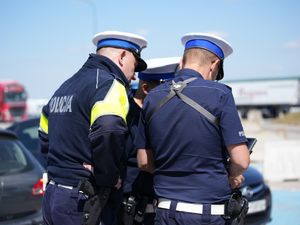 policjanci obserwują obraz z drona na kontrolerze