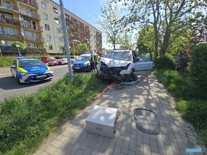 dwa radiowozy przy rozbotym samochodzie osobowym po wypadku