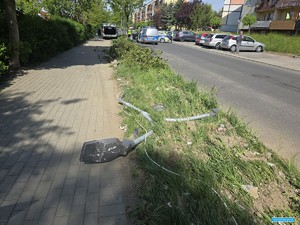 rozrzucone po chodniku zniszczone części lampy ulicznej