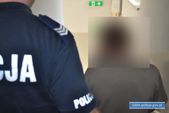 policjant prowadzi zatrzymanego