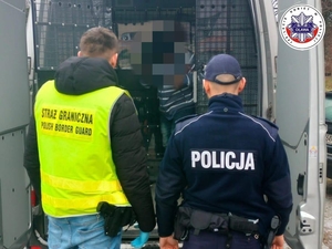 policjant prowadzi zatrzymanego