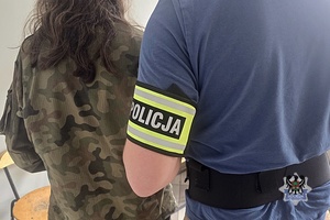 zatrzymama osoba stojaca z policjantem
