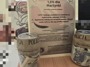 plakat ze zbiórką pieniędzy na chorą dziewczynkę oraz puszki z zebranymi pieniędzmi
