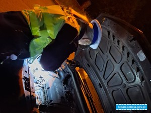 policjant sprawdza silnik samochodowy pod maską