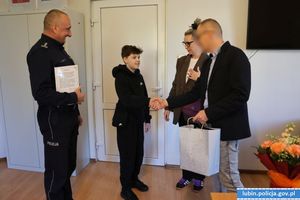 policjant ściska dłoń chłopcu