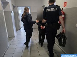 policjanci prowadzą zatrzymaną