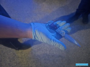 ręka mężczyzny w rękawiczce prezentujący nóż