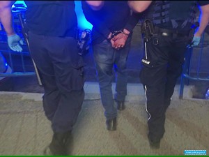 dwaj policjanci prowadzą zatrzymanego mężczyznę